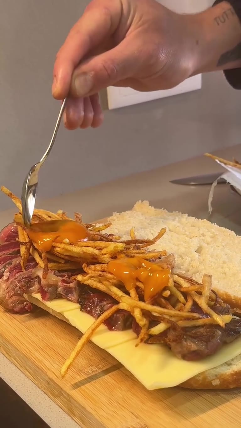 Bocadillo de entrecot con cheddar, patata paja y yema macerada en soja